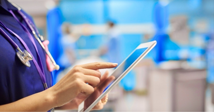 A healthcare worker reviewing protected patient records on a laptop