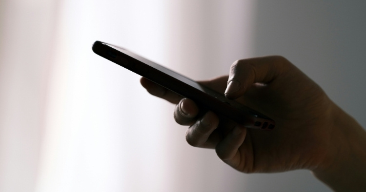 Hand holding a phone, texting